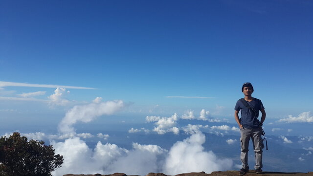 Young man standing against blue sky