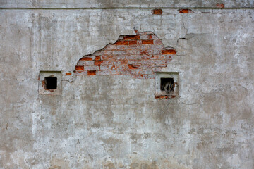 fragment of the whiteeashed briks wall of old building with the spot of  red briks oand three strange wholes