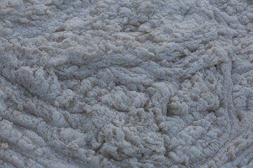 Funny picture created by water foam on coastline of lake with reflection sunrise sun on it surface