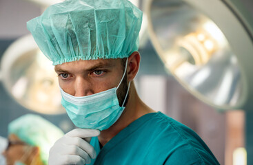 Portrait of a tired male surgeon at workin hospital. Healthcare pandemic people concept