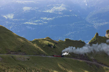Amazing hiking day in the alps of Switzerland. A beautiful locomotive drives on to a mountain and a...
