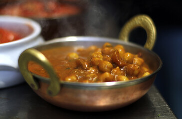 curry de garbanzos con especias al estilo indio caliente saliendo humo en bol hindú