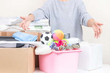 Woman extending hands, stretching out arms take donation. Volunteer collecting pet food and supplies, preparing donated items to boxes for animal shelters