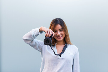 Close up of photographer smiling at camera while taking photo with professional dslr, beautiful...