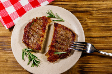 Grilled pork steaks with rosemary on wooden table. Top view