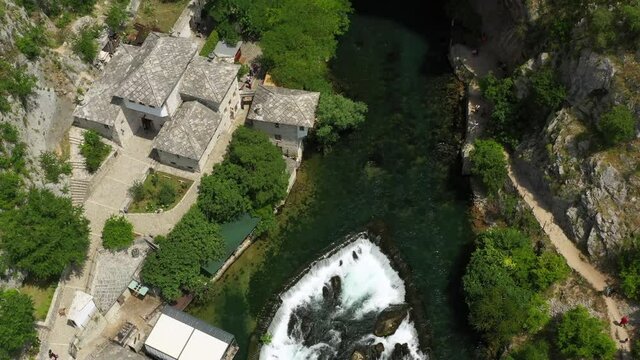 Aerial Time Lapse Tilt Up Shot Of Tourists Exploring Structures At Vrelo Bune, Drone Flying Backwards Over Buna River - Blagaj, Bosnia and Herzegovina