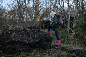 Naklejka premium girl climbs a stone in the woods