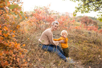 Naklejka na ściany i meble happy child and mother with golden and red trees