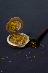 Makeup powder and cosmetic brush with golden stars on black background