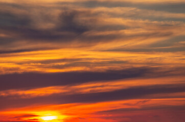 Naklejka na ściany i meble dramatic fiery sunset with clouds and bright sun.