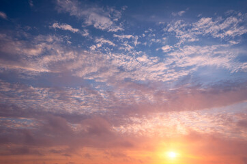 Soft sunset in the sky and cirrus clouds with bright sun.