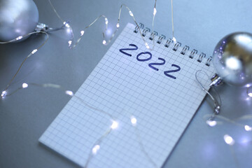 new year notepad with plans, light bulbs, garlands, balls