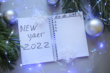 new year notepad with plans, light bulbs, garlands, balls