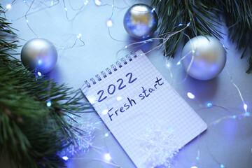new year notepad with plans, light bulbs, garlands, balls
