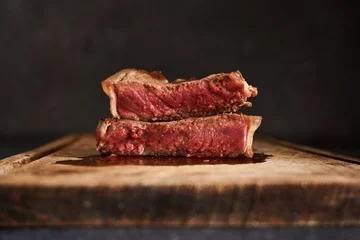 Gordijnen Closeup shot of a rare steak on a wooden table © Juan Dib/Wirestock