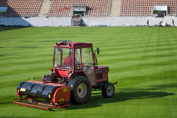 Man in tractor aerating a soccer field.