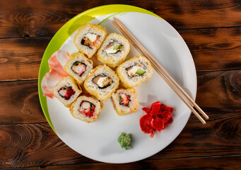 sushi with pickled ginger and wasabi on a plate on the background of a wooden table made of boards. top view.
