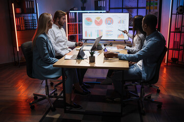 Woman presenting financial report of worldwide market on big monitor during meeting with...