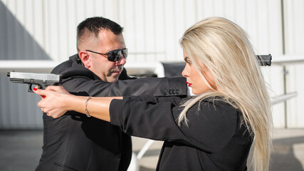 Professional female and male security spy agents posing with guns