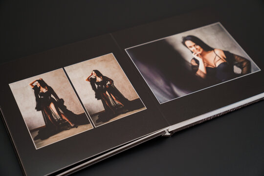 open photobook from a photo shoot of an attractive woman on a black background. 