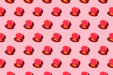 pattern of red pills. Trending image on a pink background. Medication harm concept