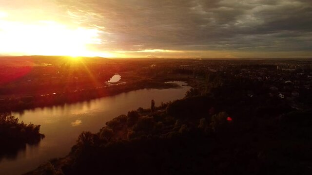 View of the Shevchenko lake in the park in Kolomyia during sunset. The Prut river in the distance. Trees and water. Drone Video. Ukraine. Europe 