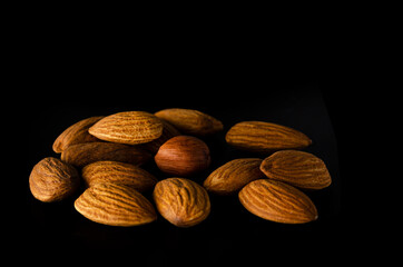 Appetizing almonds on a dark background. Mountain of almond mountains