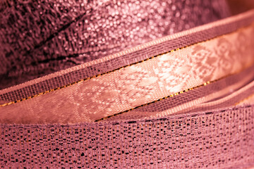 Macro abstract texture background of fabric ribbon in a shimmering shade of rosy pink
