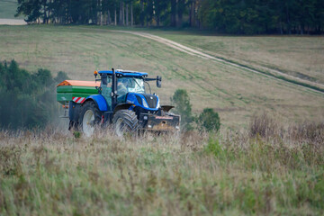 large blue New Holland T7.260 tractor fitted with an Amazone Profis Hydro hopper spreader