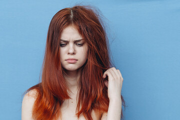 pretty woman combing naughty hair blue background
