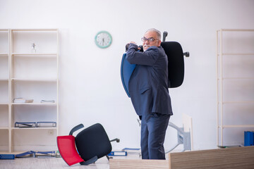 Old male employee working overtime in the office