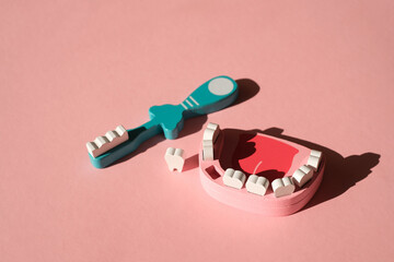 A toothbrush and a wooden toy model of a jaw with one lost tooth. Dental hygiene and oral care....