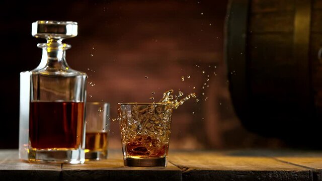 Super slow motion of falling ice cube into whiskey drink. Filmed on high speed cinema camera, 1000 fps.