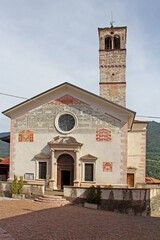Fototapeta premium la Chiesa Parrocchiale dell'Assunta a Dasindo (Trentino) col campanile antico, il portale cinquecentesco e le decorazioni liberty in facciata