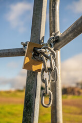Fototapeta premium Padlock with metallic chain on the metallic gate