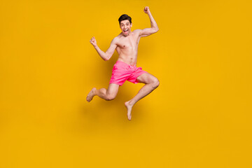 Fototapeta na wymiar Full length body size view of attractive cheery lucky guy jumping having fun isolated over bright yellow color background