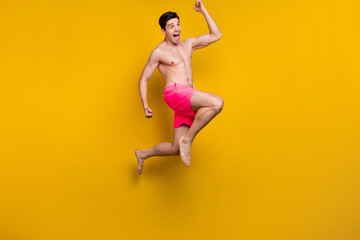 Fototapeta na wymiar Full body photo of hooray millennial guy jump wear pink shorts isolated on yellow background
