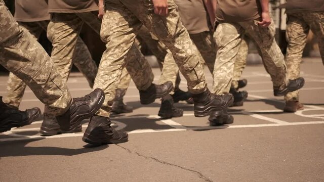 Soldiers in camouflage march on the square