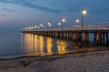 Obraz premium Baltic sea coast, night view of pier at Gdynia Orlowa sea resort, Poland.