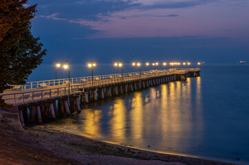 Fototapeta na wymiar Baltic sea coast, night view of pier at Gdynia Orlowa sea resort, Poland.