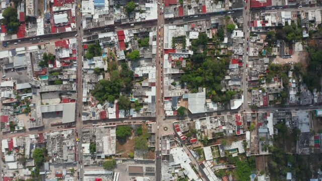 Aerial birds eye overhead top down panning view of town with streets and blocks of houses. Square pattern of city. Valladolid, Mexico