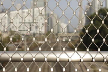 Fototapeta premium Closeup of Steel fencing with blurred urban background 