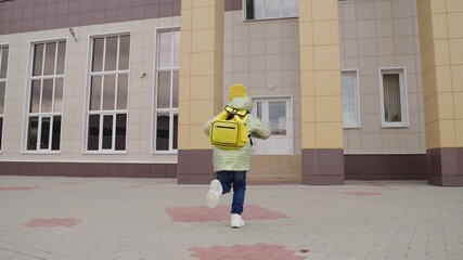 small child with backpack rushes to school for lesson, kid with school bag on his shoulders runs to the classroom, children's primary preschool education, happy family, additional student activities