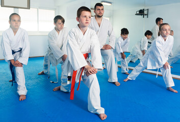 Fototapeta na wymiar Young children stretching and preparing physically to karate class