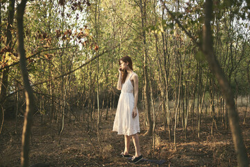 woman outdoors in the forest trees summer white dress