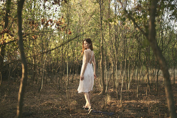 pretty woman in white dress walks in the forest nature rest