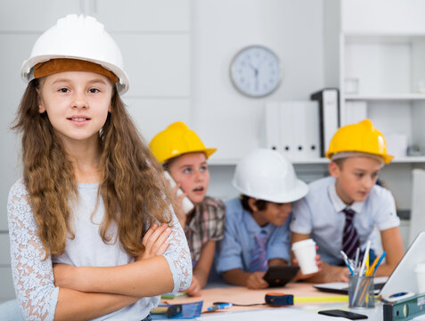 .Portrait of girl in helmet with group of children architects indoors