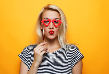 playful young woman ready for party over yellow background