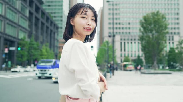 笑顔で街に立つ女性