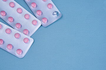 pink pills in packs vitamins pain reliever blue background